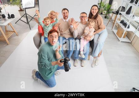 Photographe masculin avec une grande famille au shooting en studio Banque D'Images