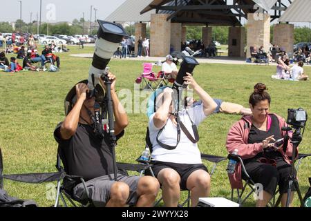 Plano, États-Unis. 8 avril 2024. Des photographes prennent des photos d'une éclipse solaire à Plano, Texas, États-Unis, le 8 avril 2024. Une éclipse solaire totale balayait l'Amérique du Nord lundi, alors que les résidents et les visiteurs se rassemblaient à différents endroits sur le chemin de l'éclipse pour regarder et encourager. L'éclipse solaire totale -- surnommée la Grande éclipse américaine pour son long chemin au-dessus de l'Amérique du Nord -- était visible dans le ciel au-dessus de certaines parties du Mexique, de 15 états américains et de l'est du Canada. Crédit : Dan Tian/Xinhua/Alamy Live News Banque D'Images