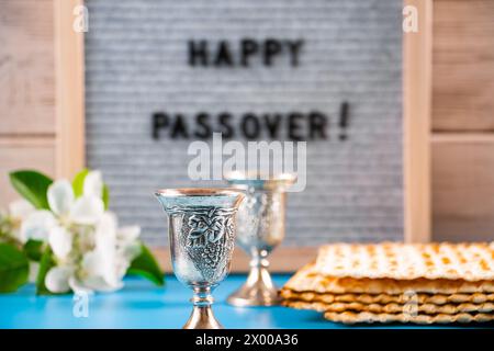 Joyeuse Pâque. Verres à vin en métal et pain matzo juif traditionnel. Célébration de la fête religieuse du printemps. Banque D'Images