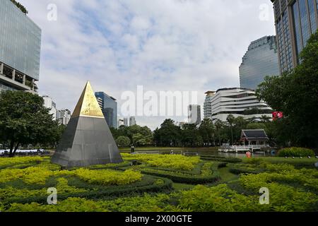 Sculpture pyramidale dans le parc Benchasiri et lac ornemental face à Sukhumvit Road, un espace vert urbain populaire à Phrom Phong, flanqué de centres commerciaux Banque D'Images