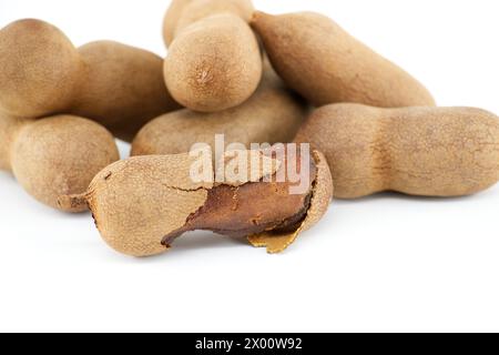 Fruits de tamarin, entiers et fendus ouverts isolés sur fond blanc (Tamarindus indica) Banque D'Images