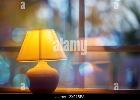 Lampe jaune confortable sur un fond bokeh bleu. Banque D'Images