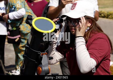 Non exclusif : une personne observe l'éclipse solaire à l'aide d'un télescope pendant la Grande éclipse solaire nord-américaine à Mexico, Mexique. Personnes Banque D'Images