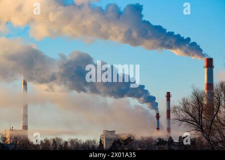 Vue de hautes cheminées fumant dans des bouffées de vapeur, paysage industriel Banque D'Images