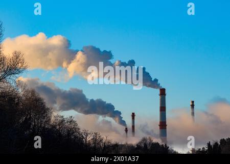 Vue de hautes cheminées fumant dans des bouffées de vapeur, paysage industriel Banque D'Images