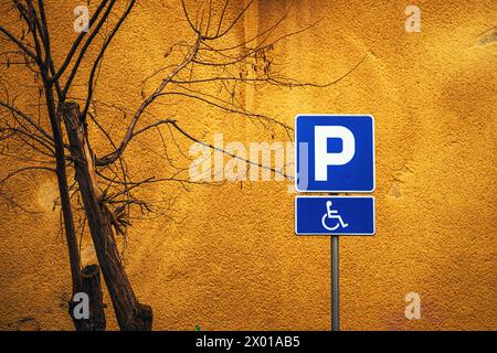 Panneau d'espace de stationnement accessible contre un mur jaune vif, espace de copie inclus Banque D'Images