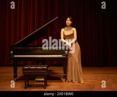 Piano, théâtre et musicien asiatique pour musique classique prêt pour un concert ou une performance. Portrait, rideau et comédie musicale dans une grande salle pour solo sur un Banque D'Images