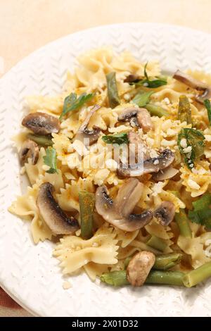 Pâtes végétariennes avec champignons, persil, haricots et fromage sur table texturée orange, gros plan Banque D'Images