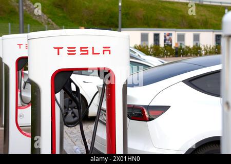 Bavière, Allemagne - 7 avril 2024 : Tesla Model y charge la batterie à une station de charge rapide Tesla Supercharger *** Tesla Model y lädt den Akku an einer Tesla Schnellladestation Supercharger Stromtankstelle Banque D'Images