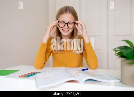 Happy Teen Girl étudiant avec Workbooks à la maison Banque D'Images