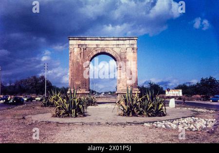 Arc de Berà, un ancien arc de triomphe près de Roda de Bera sur la route N-340 vers Sitges, Espagne, en août 1965. Le panneau indique Sitges 37kM. L'Arc de Berà a été construit à cheval sur la via Augusta à la fin du Ier siècle av. J.-C. Banque D'Images