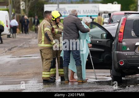 Les pompiers évacuent un résident âgé près de Rope Walk à Littlehampton, West Sussex, après que la rivière Arun a éclaté ses berges pendant la nuit. Le Service d'incendie et de sauvetage du Sussex de l'Ouest a averti les habitants de Littlehampton de graves inondations à la suite de la tempête Kathleen. Date de la photo : mardi 9 avril 2024. Banque D'Images