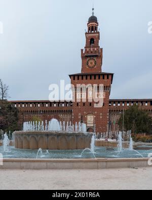 Belle vue de l'entrée principale du château des Sforza - château des Sforzesco et fontaine en face de lui, jour couvert, Milan, Italie. Banque D'Images