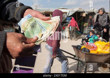 Changeur d'argent aux champs Elisee Mohammed est un changeur d'argent à l'intérieur du camp de réfugiés Al Za atari. Il est l'un des cinq ou six. Il aide les réfugiés, les migrants et les visiteurs à l'intérieur du camp à échanger toutes sortes d'argent en argent local, en espèces, qu'ils peuvent dépenser dans les magasins et les magasins à arpenter le camp. Al Za atari, Al Mafraq, Jordanie. Mafraq réfugiecamp Al Za atari Al Mafraq Jordan Copyright : xGuidoxKoppesxPhotox Banque D'Images