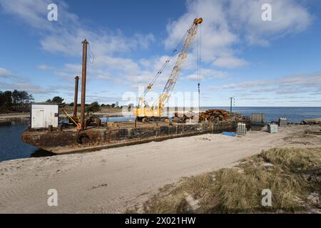 Prerow, Nothafen Darßer Ort wird zurückgebaut. Ein Schiff lädt den Schrott des ehemaligen Anlegers. Prerow, Neubau der Seebrücke mit Inselhafen, Rückbau des Nothafens *** Prerow, Darßer Ort port de refuge est démantelé Un navire charge la ferraille de l'ancienne jetée Prerow, nouvelle construction de l'embarcadère avec port insulaire, démantèlement du port de refuge Banque D'Images