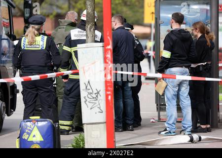 Hambourg, Allemagne. 09th Apr, 2024. Des désintégrateurs de la police de Hambourg et d'autres services d'urgence discutent d'une opération dans une succursale de la banque postale à Hambourg-Lurup. Une succursale de la banque postale dans le Lurup-Center de Hambourg et dans les rues environnantes a été bouclée mardi matin et des équipes d'élimination des explosifs ont été appelées. Crédit : Bodo Marks/dpa/Alamy Live News Banque D'Images