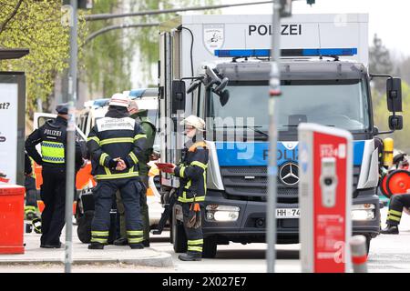 Hambourg, Allemagne. 09th Apr, 2024. Les services d'urgence et un véhicule de désintégrateurs de la police de Hambourg se tiennent devant une succursale de la banque postale à Hambourg-Lurup pendant une opération. Une succursale de la banque postale dans le Lurup-Center de Hambourg et dans les rues environnantes a été bouclée mardi matin et des équipes d'élimination des explosifs ont été appelées. Crédit : Bodo Marks/dpa/Alamy Live News Banque D'Images