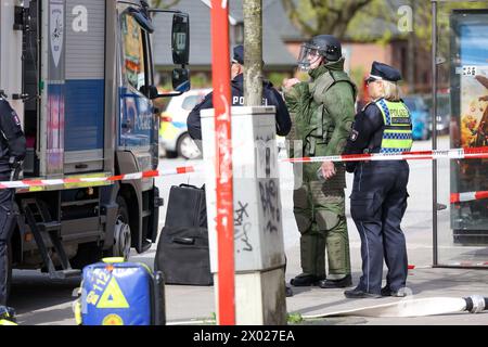 Hambourg, Allemagne. 09th Apr, 2024. Les désamorceurs de la police de Hambourg se préparent pour une opération dans une succursale de Postbank à Hambourg-Lurup. Une succursale de la banque postale dans le Lurup-Center de Hambourg et dans les rues environnantes a été bouclée mardi matin et des équipes d'élimination des explosifs ont été appelées. Crédit : Bodo Marks/dpa/Alamy Live News Banque D'Images