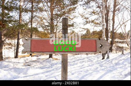 Symbole bonne chance. Mots conceptuels bonne chance sur un beau panneau routier en bois. Beau fond de ciel bleu neige de forêt. Affaires, motivation bonne chance c Banque D'Images