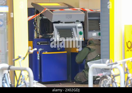 Hambourg, Allemagne. 09th Apr, 2024. Un désintégrateur de la police de Hambourg inspecte plusieurs distributeurs automatiques de billets lors d'une opération dans une succursale de la banque postale à Hambourg-Lurup. Une succursale de la banque postale dans le Lurup-Center de Hambourg et dans les rues environnantes a été bouclée mardi matin et des désactivateurs d'explosifs ont été appelés. Crédit : Bodo Marks/dpa/Alamy Live News Banque D'Images