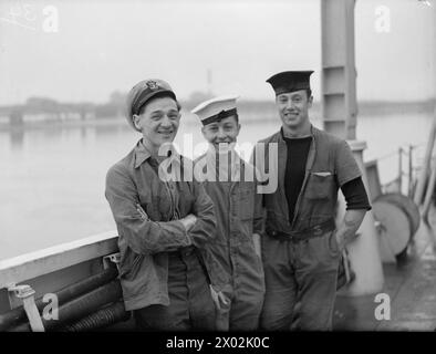 LES FRÉGATES D'ESCORTE OBTIENNENT DEUX U-BOOTS DE PLUS. 30 MARS 1944, BELFAST. LES FRÉGATES DU 1ER GROUPE D'ESCORTE, LE HMS AFFLECK, ET SES NAVIRES JUMEAUX GORE, GOULD ET GARLIES DÉTRUISENT DEUX SOUS-MARINS DANS L'ATLANTIQUE. PHOTOS DE RETOUR DU GROUPE. - Trois membres du personnel de la salle des machines d'AFFLECK. De gauche à droite ; Stoker P/O A A Clayton, de Saddleworth, Yorks ; P/O intérimaire R H Croucher, d'Aldershot ; Stoker J Smith, de Greetland, près de Halifax, Yorks Banque D'Images