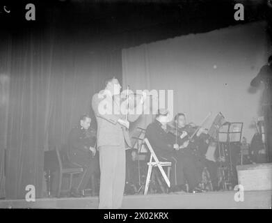 MENUHIN JOUE POUR LA FLOTTE BRITANNIQUE. SEPTEMBRE 1944, SCAPA FLOW. LORS DE L'UN DES CONCERTS DONNÉS PAR YEHUDI MENUHIN, VIOLONISTE DE RENOMMÉE MONDIALE, À LA FLOTTE BRITANNIQUE. IL A ÉTÉ DIVERTI DANS LE NAVIRE AMIRAL PAR LE C IN C, L'AMIRAL SIR HENRY MOORE, KCB, CVO, DSO. - Une étude typique de Menuhin jouant les yeux fermés Banque D'Images