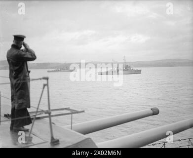 DÉMINAGE. OCTOBRE 1940, À BORD DU CUIRASSÉ HMS RODNEY. CHAQUE FOIS QUE DES AVIONS ENNEMIS AVAIENT ÉTÉ DANS LE VOISINAGE DU MOUILLAGE DE LA FLOTTE PENDANT LA NUIT, IL EST ASSEZ CERTAIN QUE DES MINES ONT ÉTÉ POSÉES ET LES DRAGUEURS DE MINES ONT BEAUCOUP DE TRAVAIL. - Les dragueurs de mines BRAMBLE et SPEEDY passant près de RODNEY en sortant du port. Leurs balayages peuvent être vus à la traîne Banque D'Images