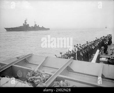 L'AUGUSTA ET SON ESCORTE DANS LA MANCHE. LE 14 JUILLET 1945, À BORD DU HMS ZODIAC, L'UN DES NAVIRES D'ESCORTE, S'APPROCHE DES DESCENTES. LE CROISEUR AMÉRICAIN AUGUSTA, TRANSPORTANT LE PRÉSIDENT TRUMAN À LA GRANDE RÉUNION DES TROIS, S'EST APPROCHÉ DES DOWNS AVEC SON ESCORTE DU CROISEUR BRITANNIQUE HMS BIRMINGHAM ET DES DESTROYERS HM SERAPIS, OBDURÉ, OBÉISSANT, ZÉLÉ, ZEPHYR, ET LE ZODIAC, ET LE CROISEUR AMÉRICAIN PHILADELPHIA. - Marins du HMS ZODIAC acclamant AUGUSTA lors de la séparation de la compagnie l'ayant escortée à travers la Manche United States Navy, AUGUSTA (USS), croiseur lourd (1930) Banque D'Images