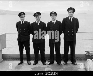 SOUS-MARINS MIDGET. 17 ET 18 DÉCEMBRE 1944, ROSYTHESAY BAY. OFFICIERS DE SOUS-MARIN MIDGET, HOMMES, EMBARCATIONS ET NAVIRE PARENT. - Midget Craft Crew. De gauche à droite : sous-lieutenant C Harding, RNVR, Bristol, plongeur ; lieutenant B E Enzer, RNVR, Kingston, Surrey, commandant; sous-lieutenant W J Lanyon-Smith, RNZNVR, Christchurch ; ERA W F Robbins, de Birmingham Banque D'Images