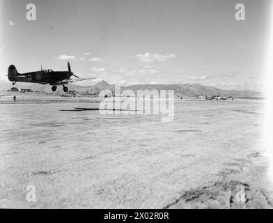 Le Supermarin Spitfire Mark VC EF566 'G' du No 335 (hellénique) Squadron RAF atterrit à Héraklion, en Crète, pour se ravitailler et se réarmer pendant les opérations de nettoyage contre la garnison allemande, avec un Vickers Wellington visible à proximité. Banque D'Images