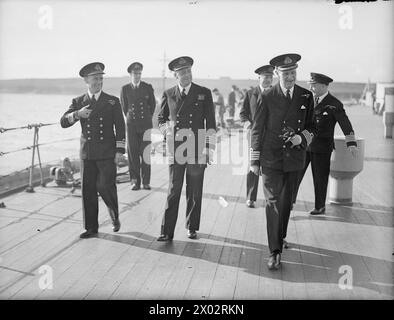 LE CAPITAINE DE LA FLOTTE QUITTE LE NAVIRE AMIRAL POUR PRENDRE LE COMMANDEMENT DU HMS ANSON. 17 JUIN 1943, SCAPA FLOW. - Capitaine E d B McCarthy, DSO, RN (à droite), avec le chef d'état-major Commodore M M Denny, CB (à gauche) et le Capitaine C E Creasy, DSO, MVO (capitaine du HMS DUKE OF YORK) marchant sur le pont avant de prendre ses adieux Banque D'Images