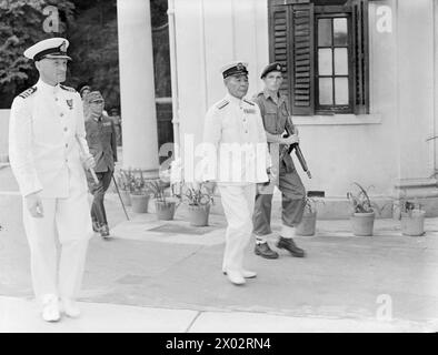 CÉRÉMONIE DE REDDITION DE HONG KONG. LE 16 SEPTEMBRE, LORSQUE LE CONTRE-AMIRAL C. H. J. HARCOURT, CB, CBE, ACCEPTE LA REDDITION INCONDITIONNELLE DE TOUTES LES FORCES JAPONAISES À HONG KONG LORS D'UNE CÉRÉMONIE DANS LA MAISON DU GOUVERNEMENT. - Le vice-amiral Ruitaka Fujita, Japon, arrive pour la cérémonie avec un Royal Marine à côté Banque D'Images