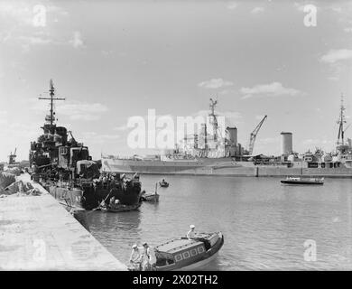 LES INTERNÉS TSINGTAO DE LA ROYAL NAVY SIDA. DU 20 AU 23 SEPTEMBRE 1945, PORT DE TSINGTAO, EN CHINE DU NORD, LORSQUE LE CROISEUR BRITANNIQUE HMS BERMUDA EST ENTRÉ DANS LE PORT POUR AIDER LES 1 800 BRITANNIQUES, AMÉRICAINS, RUSSES ET ITALIENS INTERNÉS DANS CETTE RÉGION. - HMS BERMUDA avec le destroyer américain au premier plan, dans le port de Tsingtao HMS Bermuda Banque D'Images