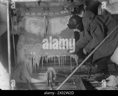 CONVOI EN RUSSIE, AVEC ESCORTE DE CROISEUR BRITANNIQUE SUR LA LIGNE DE VIE ARCTIQUE. DÉCEMBRE 1941, À BORD DU CROISEUR HMS SHEFFIELD. - Libérer les chaînes, les fils et les bornes de la glace sur le fo`c'sle Banque D'Images