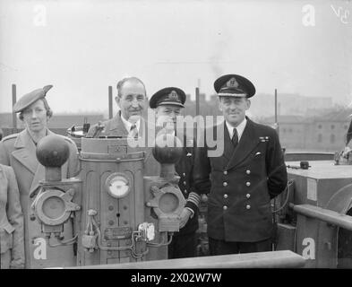 LES FRÉGATES D'ESCORTE OBTIENNENT DEUX U-BOOTS DE PLUS. 30 MARS 1944, BELFAST. LES FRÉGATES DU 1ER GROUPE D'ESCORTE, LE HMS AFFLECK, ET SES NAVIRES JUMEAUX GORE, GOULD ET GARLIES DÉTRUISENT DEUX SOUS-MARINS DANS L'ATLANTIQUE. PHOTOS DE RETOUR DU GROUPE. - Le premier ministre d'Irlande du Nord avec Lady Brooke, commandant C Gwinner, DSO, DSC, RN (à droite) et le capitaine J T Borrett, OBE, sur le pont d'AFFLECK après le retour au port du Groupe Banque D'Images