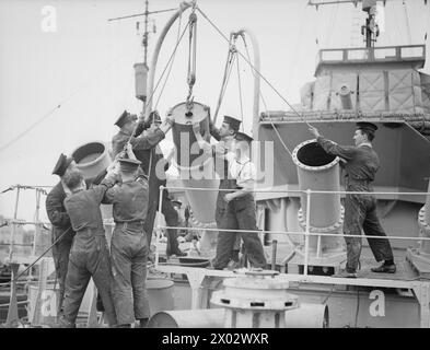 ESSAIS EXPÉRIMENTAUX DE NOUVEAUX LANCEURS DE CHARGES EN PROFONDEUR. 27 JUILLET 1941, À BORD DU HMS WHITEHALL. LES NOUVEAUX LANCEURS SONT MONTÉS SUR LE FO'C'SLE DES DESTROYERS ET SONT ACTIONNÉS À PARTIR DU PONT. - Les lanceurs en cours de chargement. Les cotes diminuent les charges de profondeur prêtes pour les essais Banque D'Images