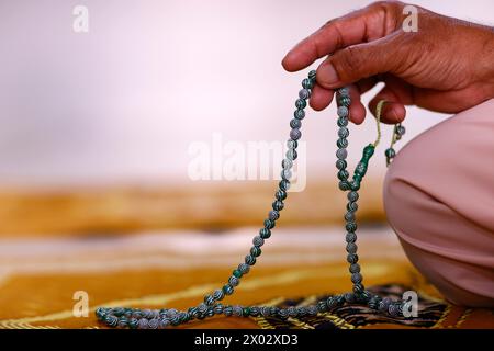 Gros plan de la main d'un homme musulman priant avec des perles de prière islamiques, Chau Doc, Vietnam, Indochine, Asie du Sud-est, Asie Banque D'Images