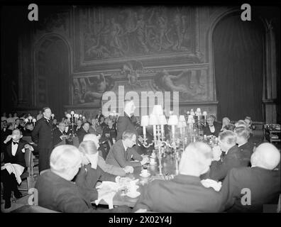 DÎNER DU CONSEIL D'ADMINISTRATION DE L'AMIRAUTÉ AUX PREMIERS MINISTRES DE L'EMPIRE. 8 MAI 1944, DANS LE PAINTED HALL DU ROYAL NAVAL COLLEGE GREENWICH. LE DÎNER ÉTAIT EN L'HONNEUR DES PREMIERS MINISTRES DE L'AUSTRALIE, DU CANADA, DE L'AFRIQUE DU SUD ET DE LA NOUVELLE-ZÉLANDE, ET ÉTAIT PRÉSIDÉ PAR LE PREMIER LORD DE L'AMIRAUTÉ, M. A. V ALEXANDER. - M. J. H. Curtin, premier ministre de l'Australie, s'exprimant lors du dîner. À sa droite se trouve Lord Cranborne, secrétaire d'État aux Affaires fédérales Banque D'Images