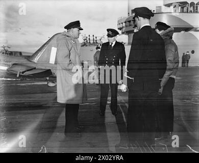 BRAS PNEUMATIQUE FLEET. 7 JANVIER 1942, À BORD DU HMS VICTORIOUS. PILOTES DE CHASSE ET LEURS MACHINES. - Commandant (F) H C Ranald, OBE, parlant au lieutenant M Newman, RN, et à d'autres pilotes de chasse avant un programme de vol Banque D'Images