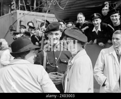 LA MARINE BRITANNIQUE SE REND AU DANEMARK. DU 7 AU 9 MAI 1945, À BORD DU CROISEUR HMS BIRMINGHAM LORS DU PASSAGE ET DE L'ARRIVÉE À COPENHAGUE. LA FORCE BRITANNIQUE SOUS LE COMMANDEMENT DU CAPITAINE H W WILLIAMS, RN, EST ENTRÉE À COPENHAGUE APRÈS LA REDDITION DES RESTES DE LA FLOTTE ALLEMANDE. - Les femmes de Copenhague discutant avec un piquet Royal Marine de BIRMINGHAM, Banque D'Images