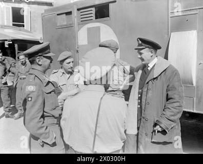 AVEC UN NAVIRE DE DÉBARQUEMENT DE CHAR D'HÔPITAL. LES 10 ET 11 AOÛT 1944, COURSSELLES, FRANCE, AVEC LST 428. SPÉCIALEMENT AMÉNAGÉ POUR CETTE TÂCHE, LE LST 428 AIDE À TRANSPORTER LES VICTIMES, Y COMPRIS LES BLESSÉS ENNEMIS, DE LA ZONE DE BATAILLE AU ROYAUME-UNI. - De gauche à droite : Colonel Brading, CMR, Major H Chapman, CMR, et capitaine chirurgien W B d Miller, DSC, RNVR, discutant des plans d'évacuation de causalité Banque D'Images