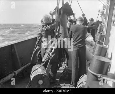 LES HOMMES DE LA CORVETTE BRITANNIQUE, HMS VERVAIN, EN SERVICE ACTIF. 9-10 JUILLET 1942. - Recharger les lanceurs de charge en profondeur Banque D'Images