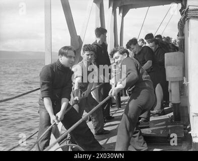 LES HOMMES DE LA CORVETTE BRITANNIQUE, HMS VERVAIN, EN SERVICE ACTIF. 9-10 JUILLET 1942. - Hisser le baleinier Banque D'Images