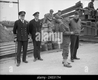 LIBÉRATION DE L'EUROPE : LES PRISONNIERS ALLEMANDS ARRIVENT EN ANGLETERRE DE NORMANDIE. 12 JUIN 1944, QUAIS DE SOUTHAMPTON. PRISONNIERS ALLEMANDS, SOLDATS, MARINS, AVIATEURS ET CIVILS ARRIVANT DE FRANCE DANS LES PORTS BRITANNIQUES. - Regardant les prisonniers débarquer sont (de gauche à droite) l'amiral Sir Charles Little, C in C Portsmouth ; le contre-amiral Pipon, FOIC Soton ; le général Lee, US Army, et un autre officier américain Banque D'Images