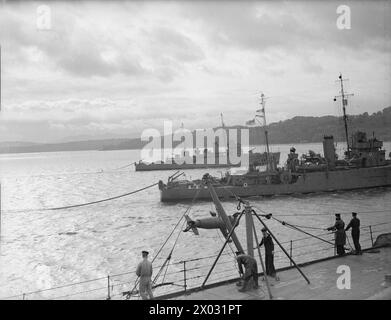 DÉMINAGE. OCTOBRE 1940, À BORD DU CUIRASSÉ HMS RODNEY. CHAQUE FOIS QUE DES AVIONS ENNEMIS AVAIENT ÉTÉ DANS LE VOISINAGE DU MOUILLAGE DE LA FLOTTE PENDANT LA NUIT, IL EST ASSEZ CERTAIN QUE DES MINES ONT ÉTÉ POSÉES ET LES DRAGUEURS DE MINES ONT BEAUCOUP DE TRAVAIL. - Les dragueurs de mines BRAMBLE et SPEEDY passant près de RODNEY en sortant du port. Leurs balayages peuvent être vus à la traîne Banque D'Images