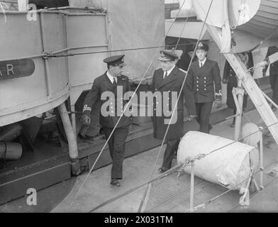 L'AMIRAL SIR MAX K HORTON, QUI A RÉCEMMENT RELEVÉ L'AMIRAL SIR PERCY NOBLE DE SON POSTE DE COMMANDANT EN CHEF DES APPROCHES OCCIDENTALES, SAISIT LA PREMIÈRE OCCASION D'INSPECTER LES NAVIRES D'ESCORTE SOUS SON COMMANDEMENT. 30 NOVEMBRE 1942. - Le nouveau commandant en chef marchant le long du pont pendant son inspection d'un destroyer Banque D'Images