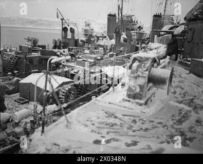 CONVOI EN RUSSIE, AVEC ESCORTE DE CROISEUR BRITANNIQUE SUR LA LIGNE DE VIE ARCTIQUE. DÉCEMBRE 1941, À BORD DU CROISEUR HMS SHEFFIELD. - Deux des dragueurs de mines recouverts de neige qui ont également escorté le convoi vers la Russie se trouvent à côté du croiseur Banque D'Images