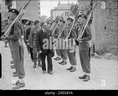 Le 14 juillet 1944, le jour de la Bastille a été observé à Arromanches avec des représentants de la Royal Navy, de l'armée britannique et de l'armée de l'air assistant à une cérémonie. Les Royal Marines fournissent une garde d'honneur inspectée par le maire, M. Paris, accompagné du major J.P. Kelly, DSM, RM, et du capitaine H. Hickling, DSO, RN. Banque D'Images