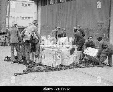 Le 14 avril 1943, un convoi en Afrique du Nord arrive à Alger, comprenant un navire américain Liberty escorté par la Royal Navy et des avions alliés, avec des ouvriers des chantiers navals déchargeant des vêtements, des fournitures médicales, du lait écrémé et du matériel de guerre. Banque D'Images