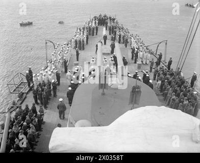 JOUR DE L'INDÉPENDANCE GRECQUE DANS LA MARINE GRECQUE. 23 FÉVRIER 1943, PORT-SAÏD, JOUR DE L'INDÉPENDANCE GRECQUE, MARS 25 ; SERA LARGEMENT CÉLÉBRÉ. LES MARINS SERVANT DANS LA SECTION GRECQUE DES MARINES ALLIÉES SE SOUVIENNENT TOUJOURS DE CE JOUR. LE CONTRE-AMIRAL A SAKELLARIOU, COMMANDANT EN CHEF DE LA ROYAL HELLENIC NAVY ARBORE SON PAVILLON DANS LE CROISEUR HHMS GIORGIOS AVEROFF. - Une vue générale depuis le haut de la tourelle du canon regardant vers le bas les divisions du matin sur le pont arrière du HHMS GIORGIOS AVEROFF Banque D'Images